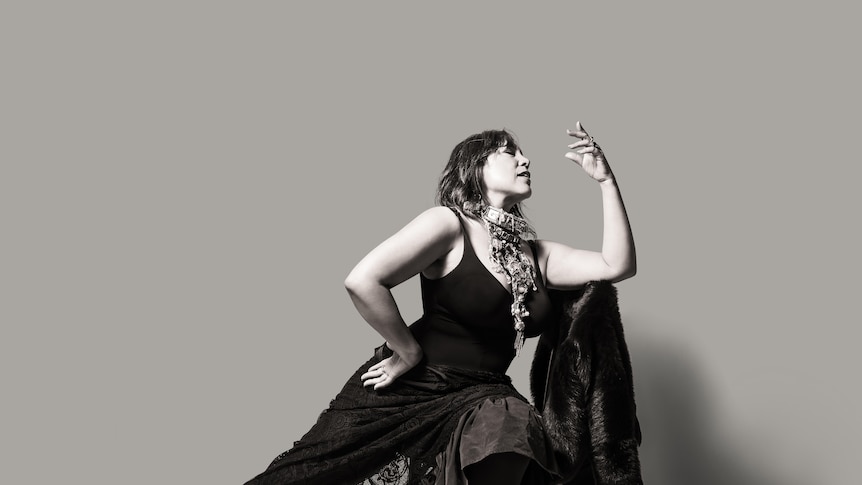 black and white photo of Kate Ceberano seated in black dress