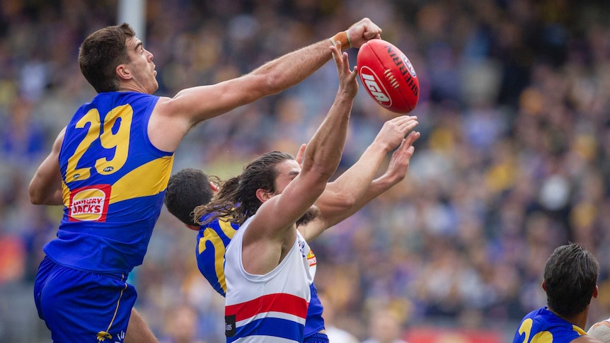 Scott Lycett punches the ball as Tom Boyd tries to mark