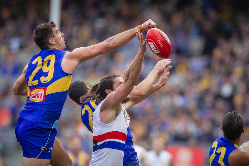 Scott Lycett punches the ball as Tom Boyd tries to mark