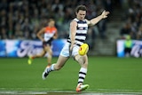 Patrick Dangerfield kicks the ball on the run for the Cats against the Giants.