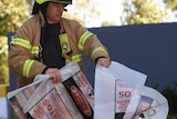 A firefighter is seen carrying a hazardous material bag into the South Korean consulate in Melbourne.