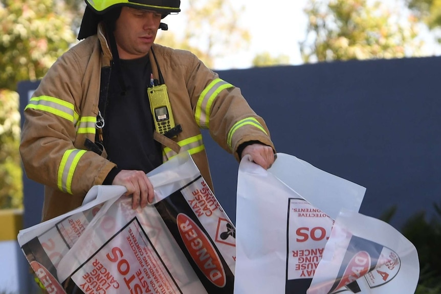 A firefighter is seen carrying a hazardous material bag into the South Korean consulate in Melbourne.