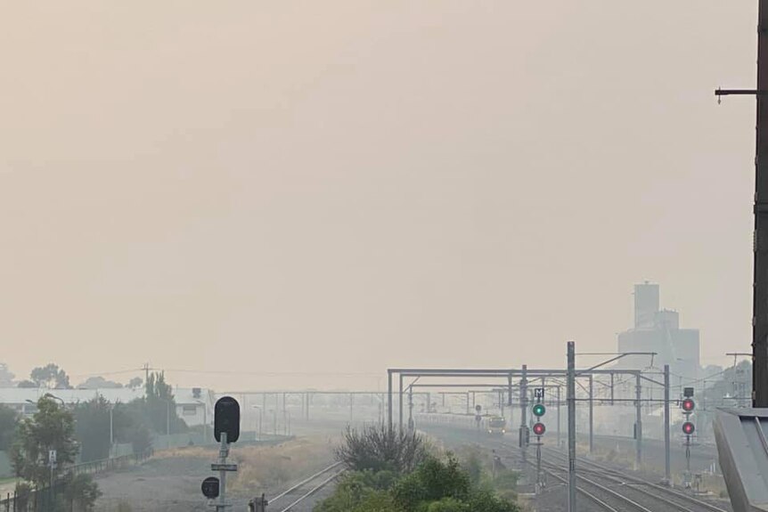 A thick haze of smoke hangs over the train tracks leading into Sunshine train station.