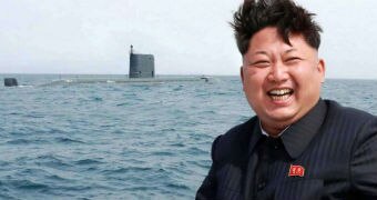 Kim Jong-un laughs into the distance while looking at a military submarine