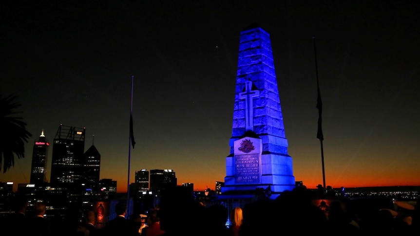 WA's State War Memorial as dawn breaks and flags at half mast.