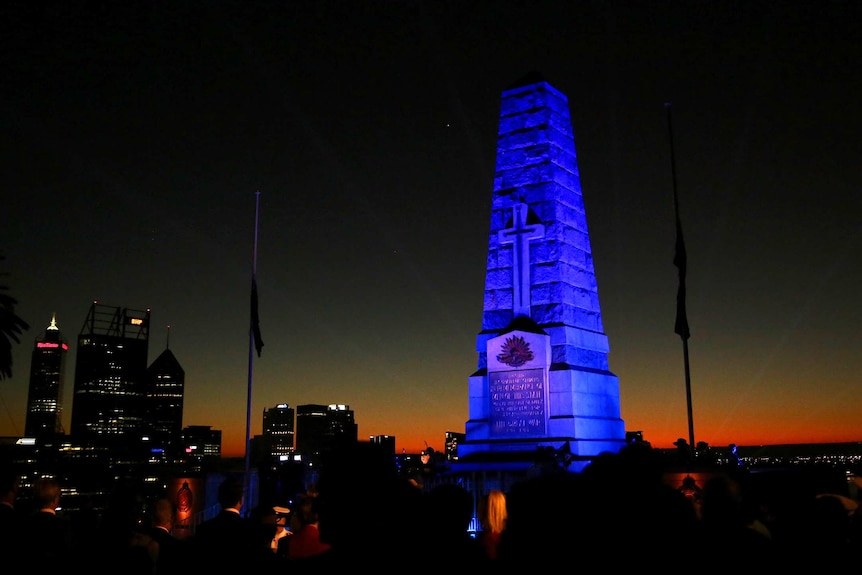 WA's State War Memorial as dawn breaks and flags at half mast.