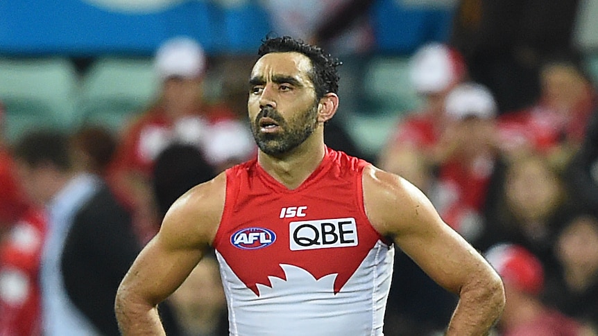 A Sydney Swans AFL players walks upright with his hands on his hips.