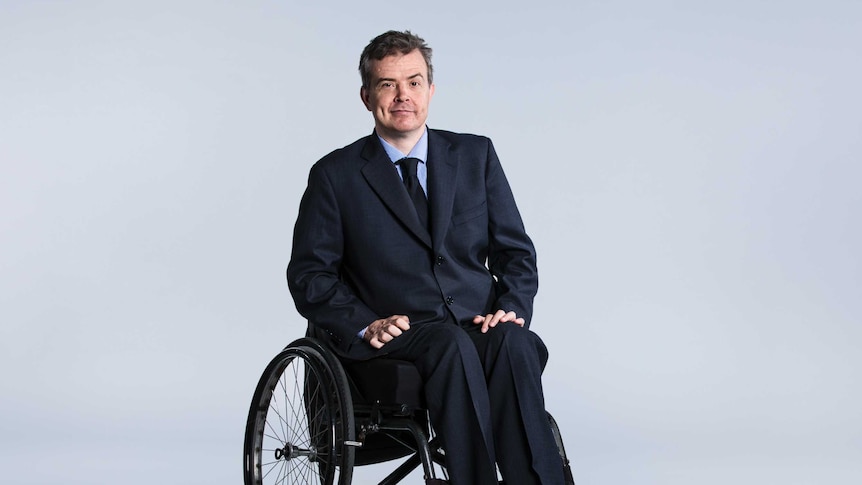 A man in a suit sitting in a wheelchair