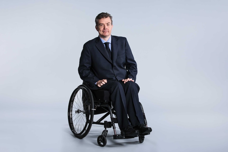 A man in a suit sitting in a wheelchair