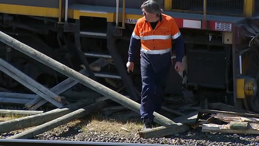 Worker walks past train crash