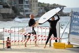 Two surfers crossing a barrier