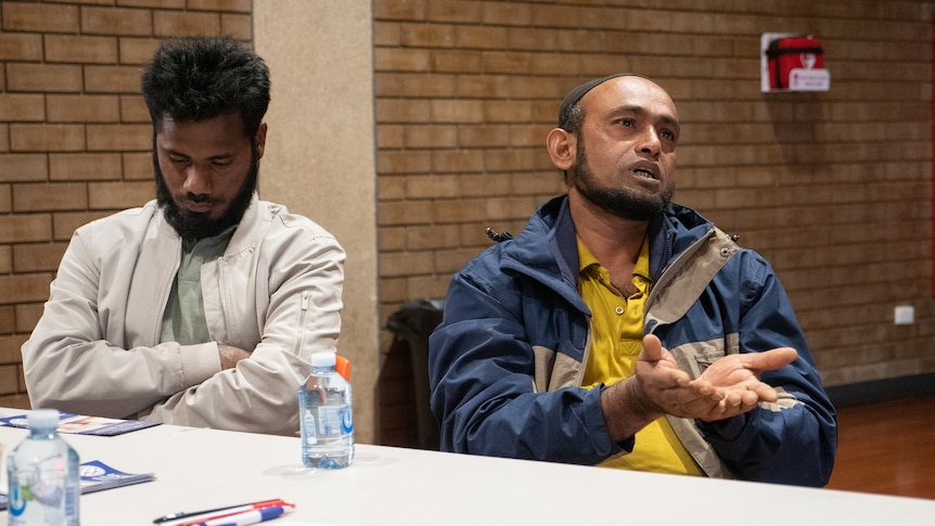 Two refugee men at a table at Gatton's shire hall, June 2022. 