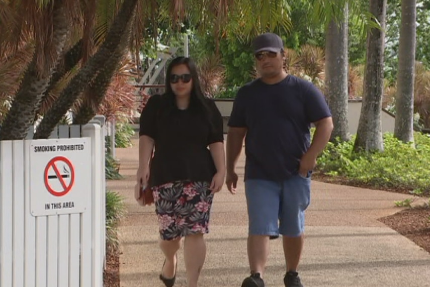 Two people walking into a courthouse.