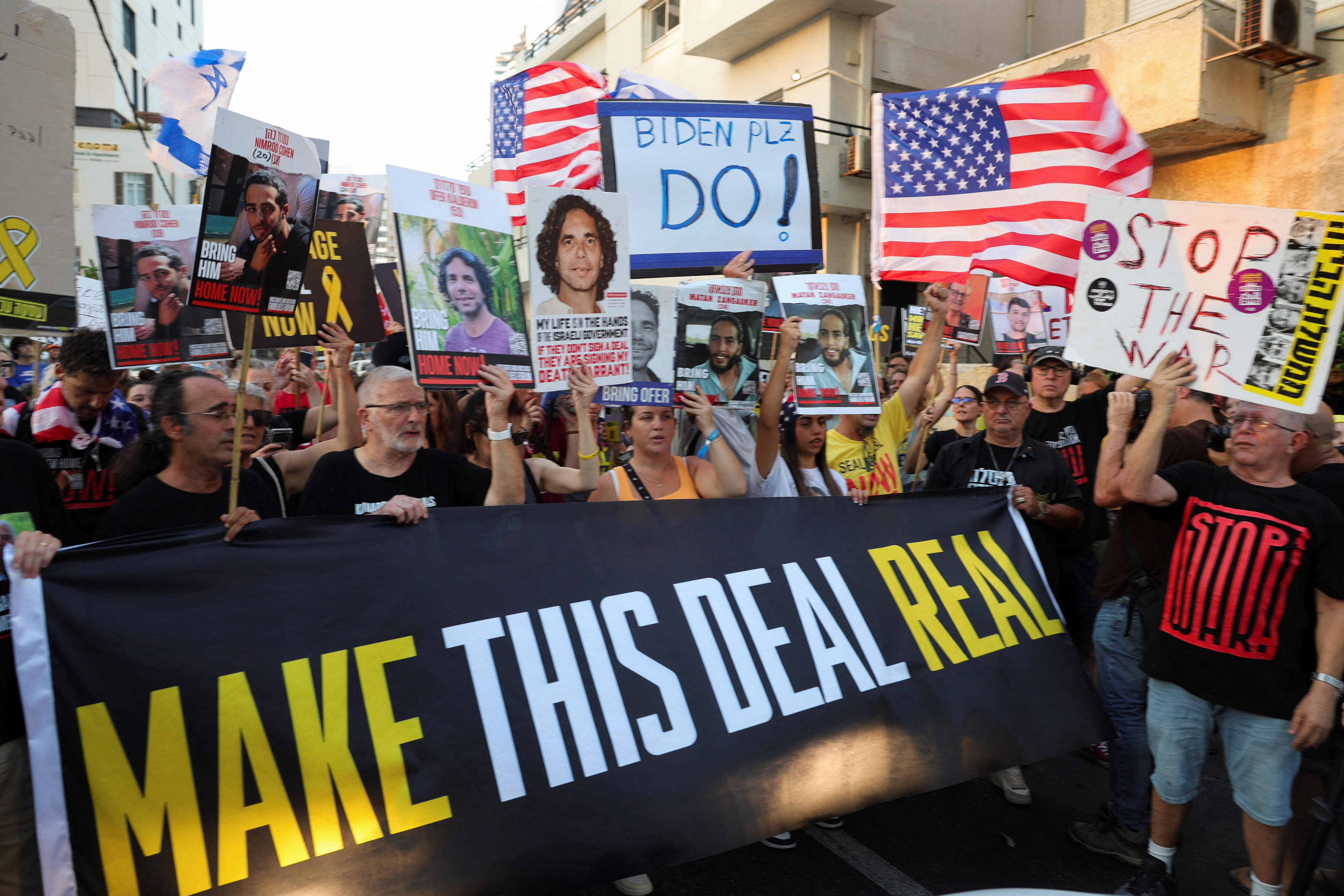 People holding a sign saying make this deal real