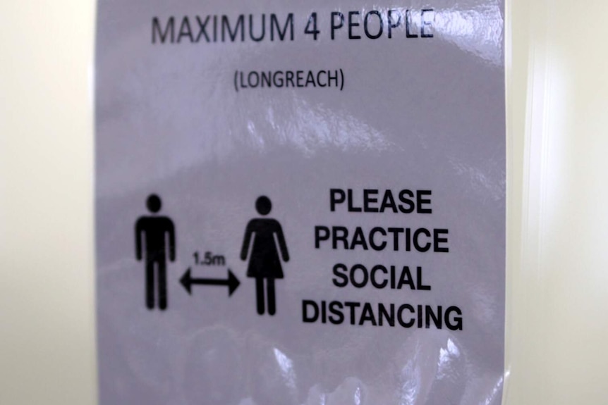 A sign urges people to maintain 1.5m distance and have a maximum four people in the room.