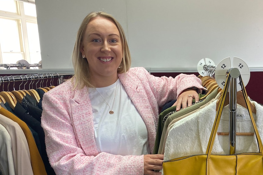 Amanda French, from Hobart's Dress for Success initiative stands amongst clothing racks. 