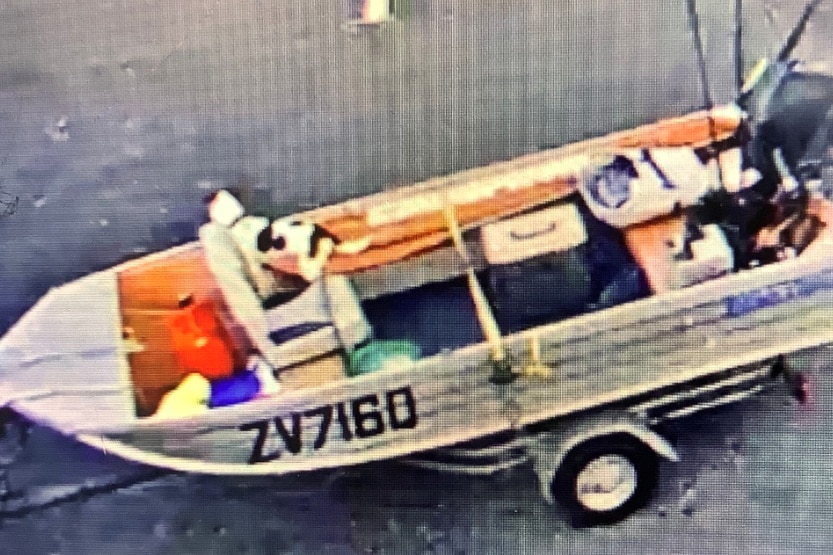 CCTV image of a boat and a small black and white dog.