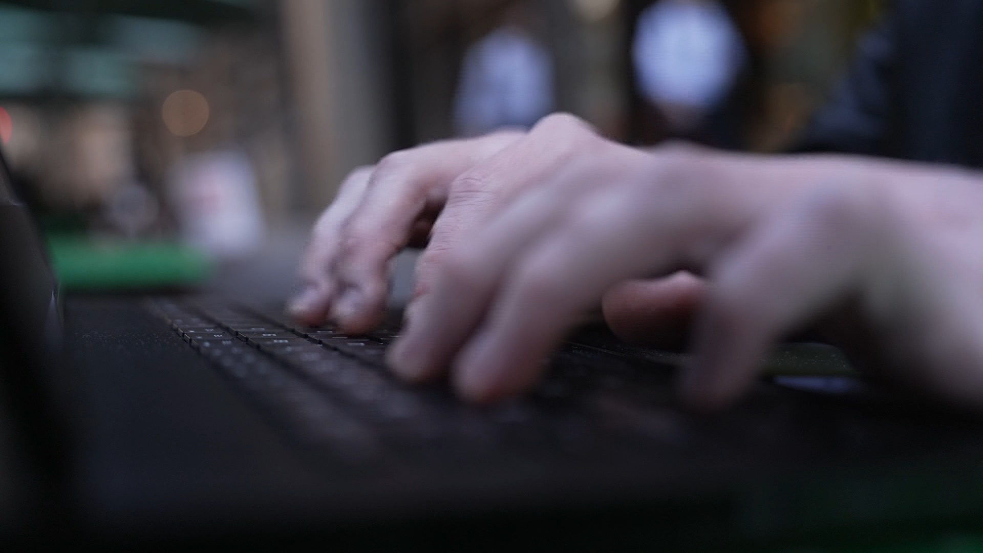 A close up of a pair of hands typing on a laptop keyboard