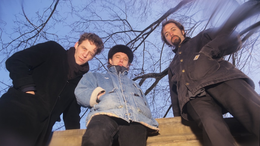 Camera looks upwards at the three members of alt-rock trio Morphine in New York City