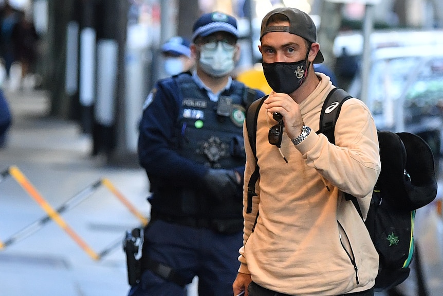Cricketer Glenn Maxwell arrives at hotel quarantine wearing a mask and baseball cap