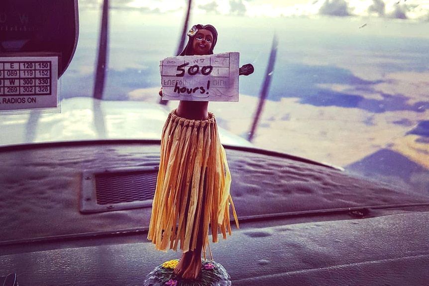 Hawaiian wobble doll holds 500 hours sign