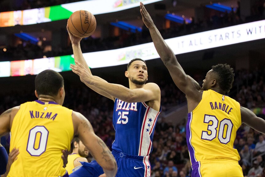 Ben Simmons shoots while being guarded by two LA Lakers players.