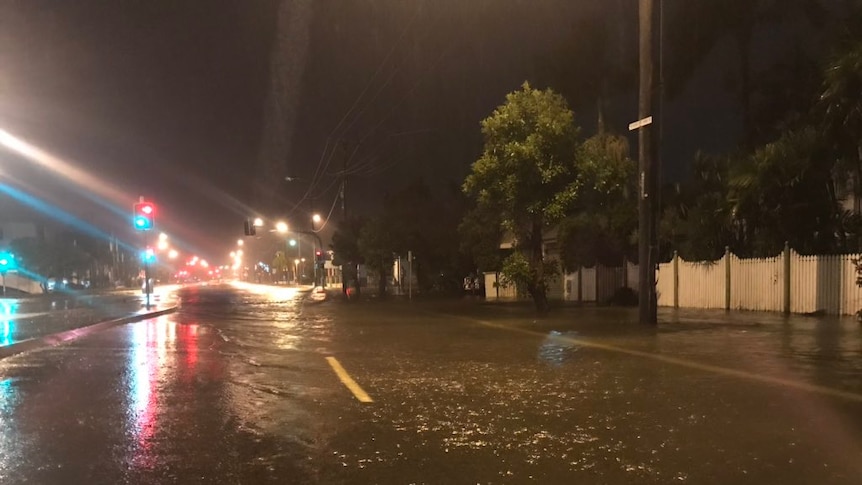 A road filled with flood water at night time in Townsville.