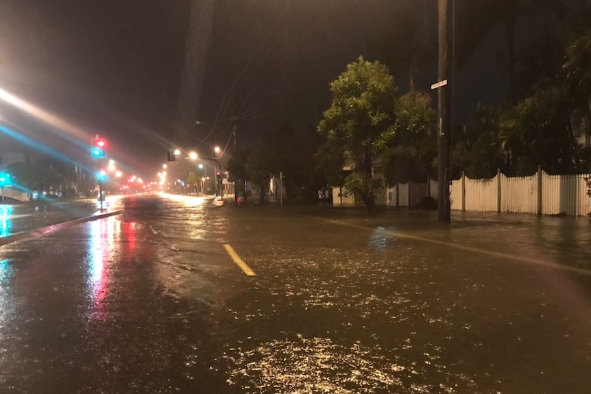A road filled with flood water at night time in Townsville.