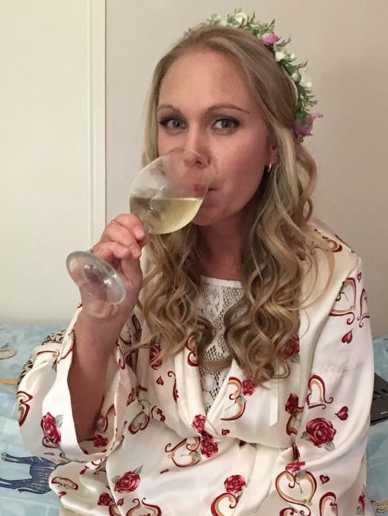 A woman sips a glass of wine