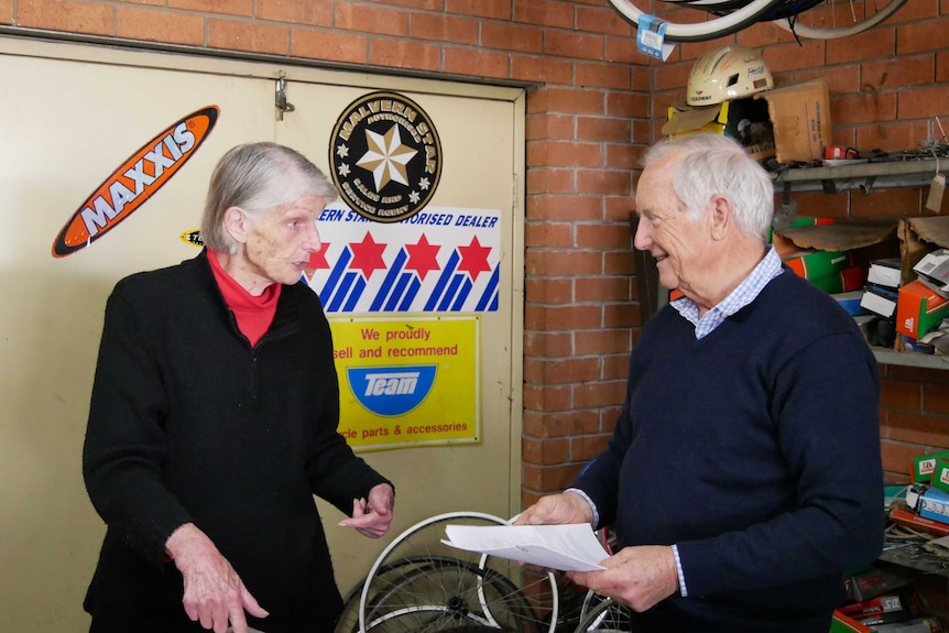 Pam and Mike talking to each other in the bike shop.