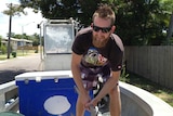 Commercial fisherman Nathan Rynn works in his boat in Townsville.