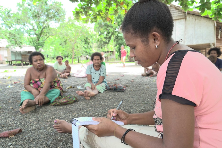 Researcher Elizabeth Tauleholo takes notes as she listens to the stories of the locals.