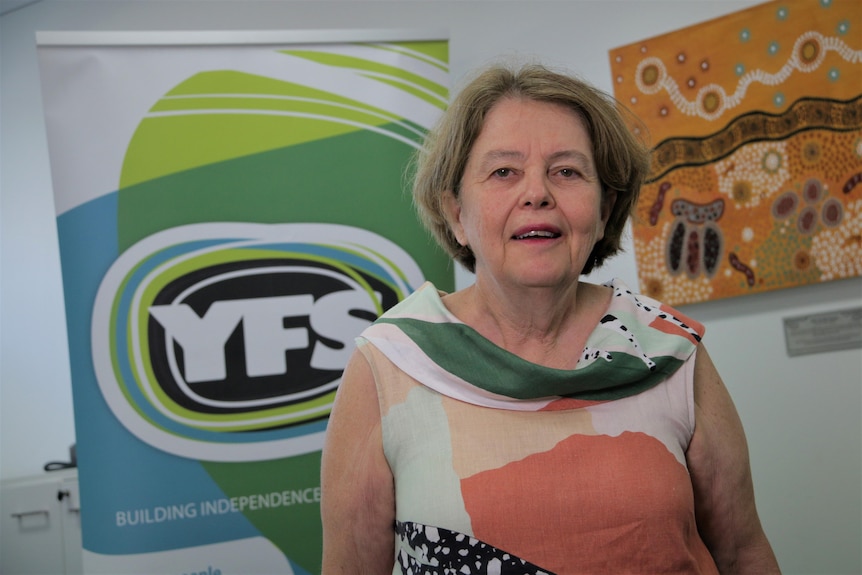 Cath Bartolo, the CEO YFS at Logan, south of Brisbane, stands in front of a sign for the group.