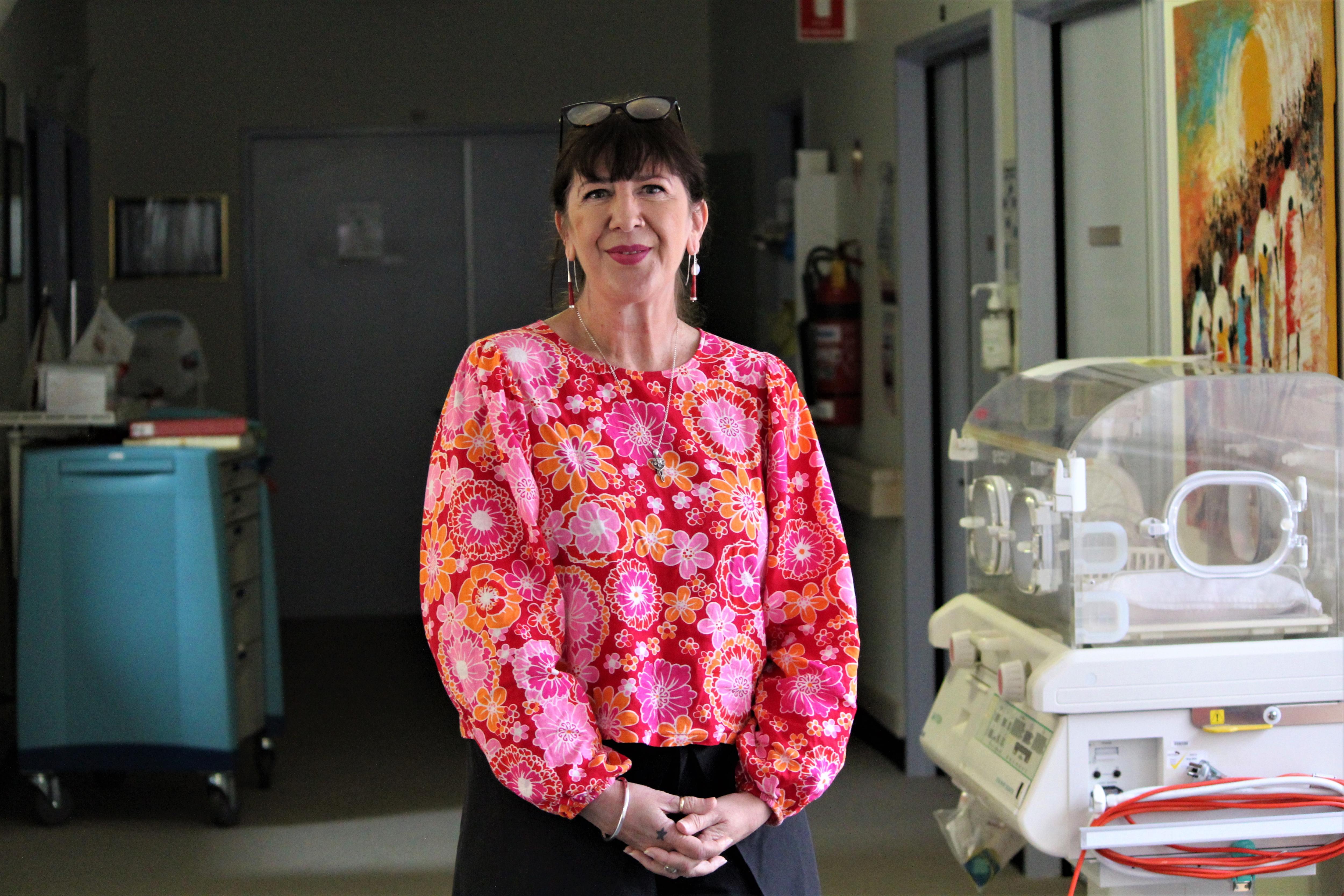 A woman stands in a maternity ward 