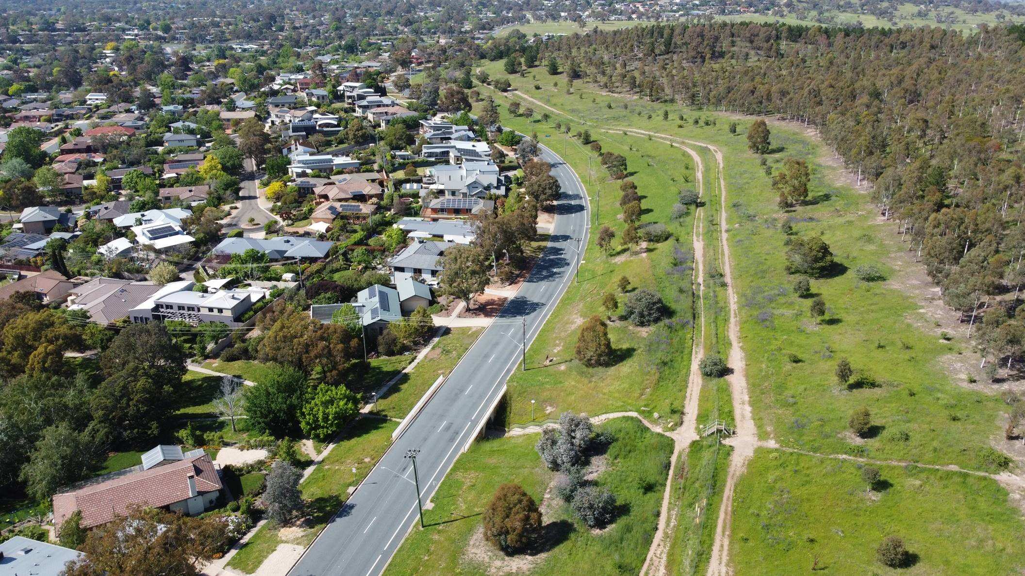 Drone shot showing grassed area near Canberra houses
