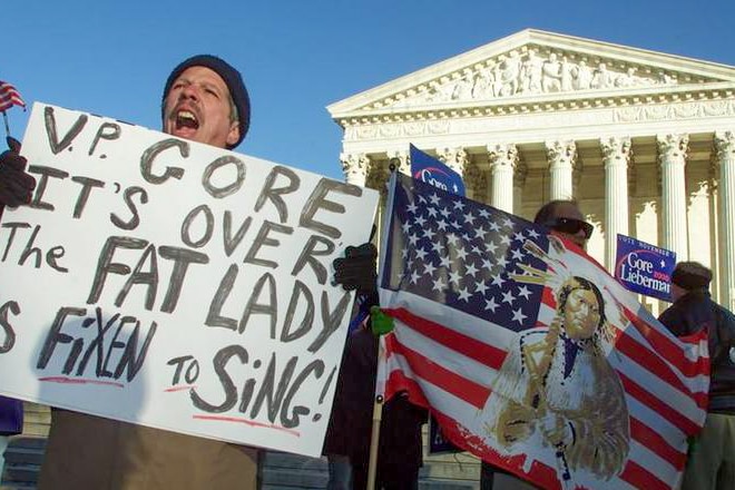 A man outside the US Supreme Court shouting while holding a sign reading 'VP Gore it's over, the fat lady is fixen to sing'