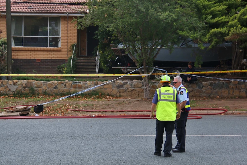 Police tape and emergency services workers around a house in Canberra's south.