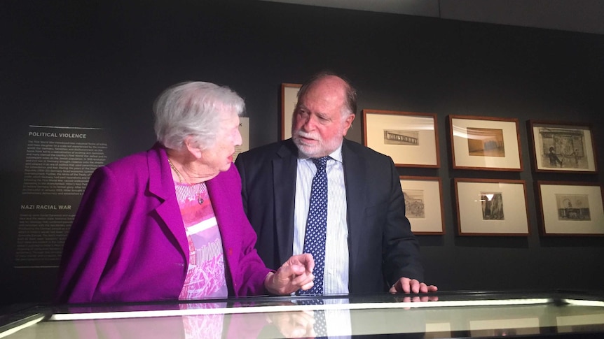 Holocaust survivor Irma Hanner and Warren Fineberg stand before a display at the AWM.