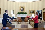 US President Barack Obama passing an AFL football with Australia's Prime Minister Julia Gillard