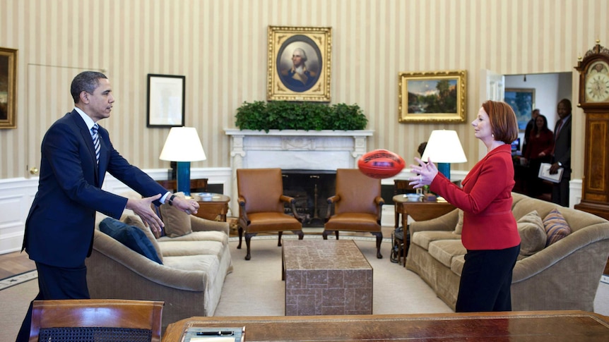 US President Barack Obama passing an AFL football with Australia's Prime Minister Julia Gillard