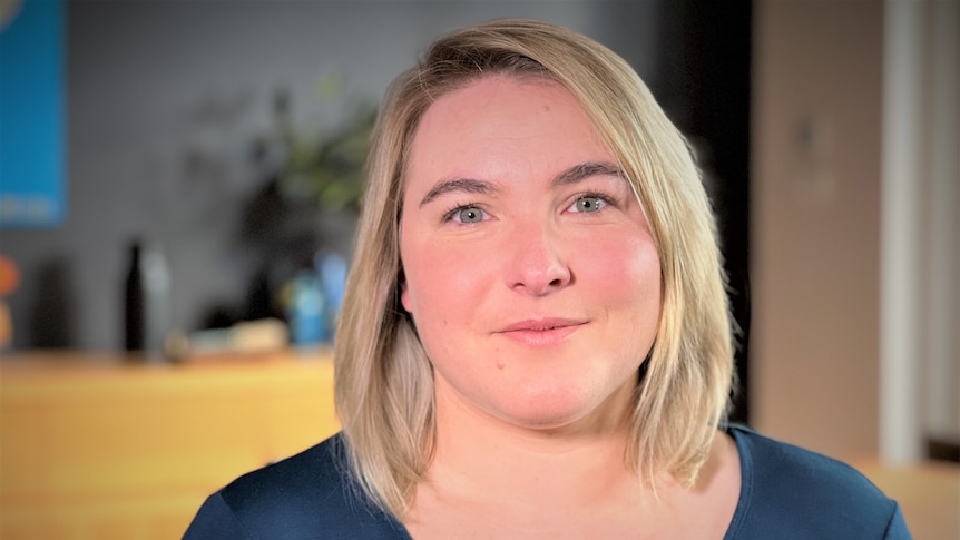 A blonde woman smiles at the camera 