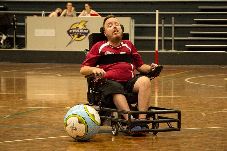 A man in a wheelchair moves towards a large ball.