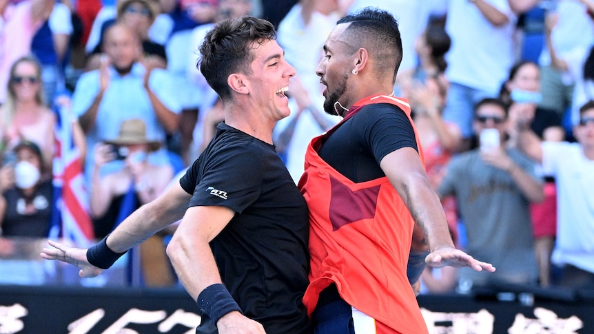 Two Australian male tennis players chest bump each other as they celebrate victory.
