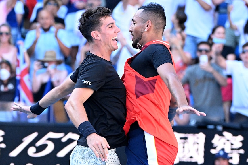 Two Australian male tennis players chest bump each other as they celebrate victory.