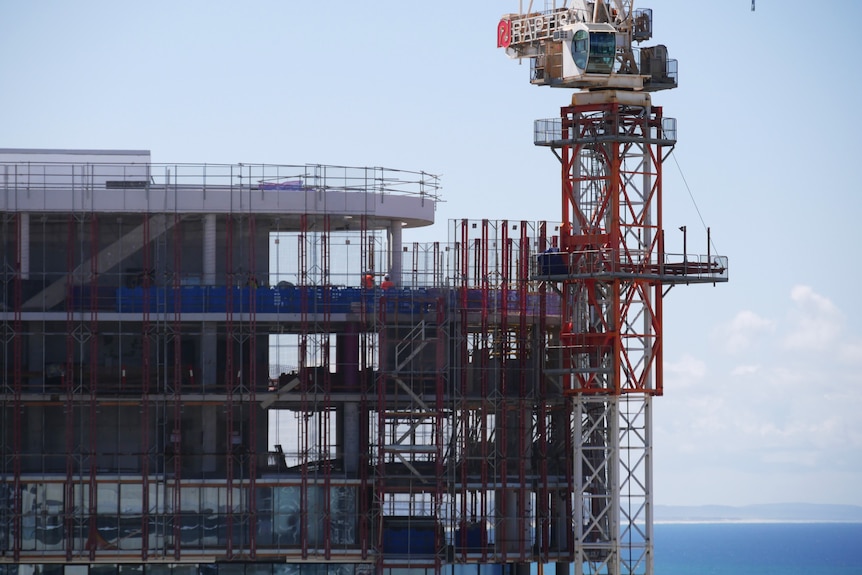 Scaffolding and a crane on a beach front apartment building.