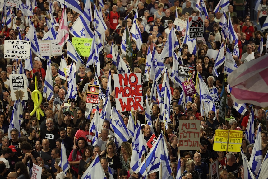 Protesters holding Israeli flags. 