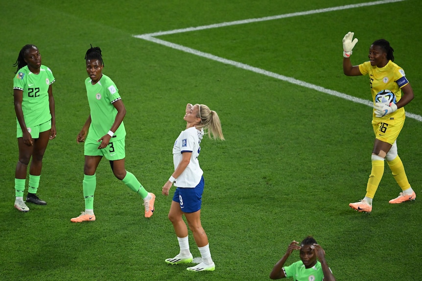 England player Rachel Daly holds her neck while surrounded by Nigeria players at the FIFA Women's World Cup.