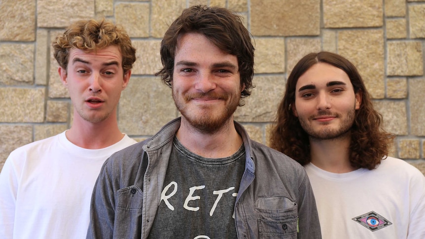 Tom Hollis, Jarrad Wright and Izak Whear standing in front of brick wall.