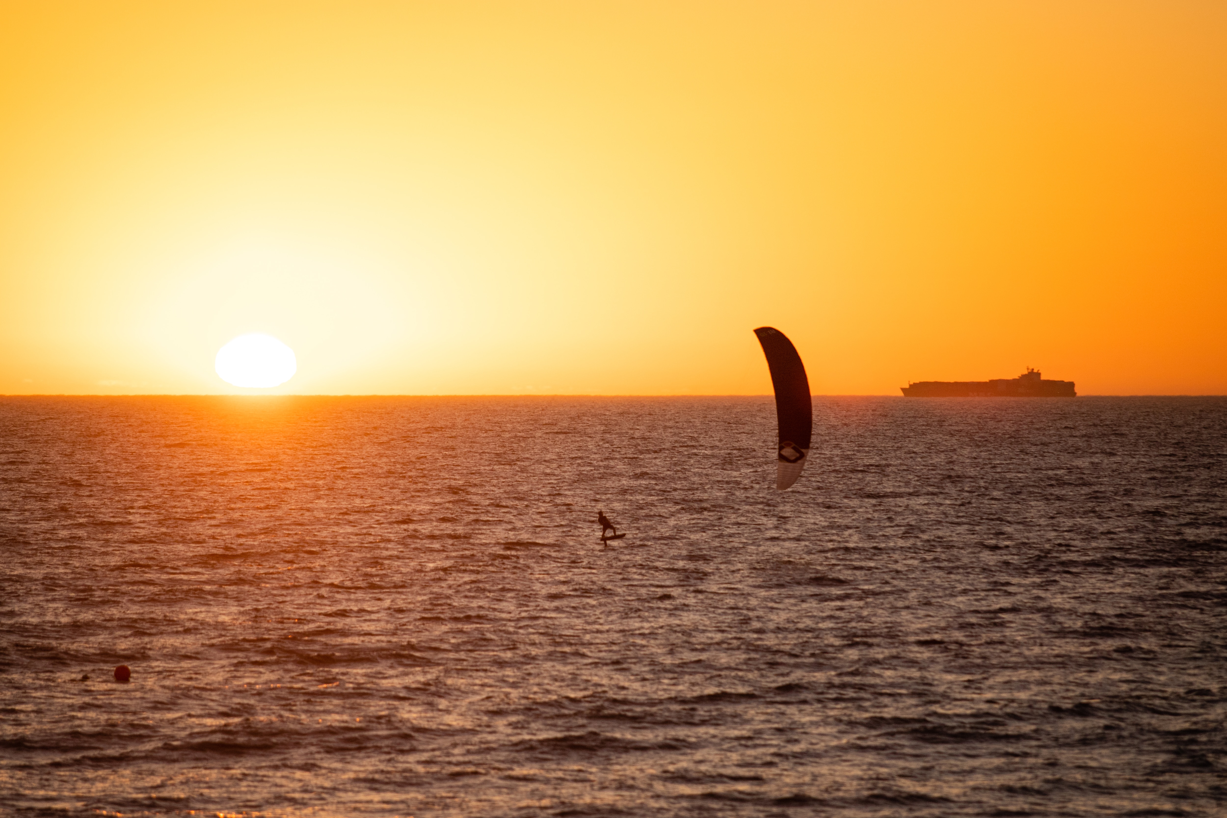Members of the public at a crowded beach during sunset.