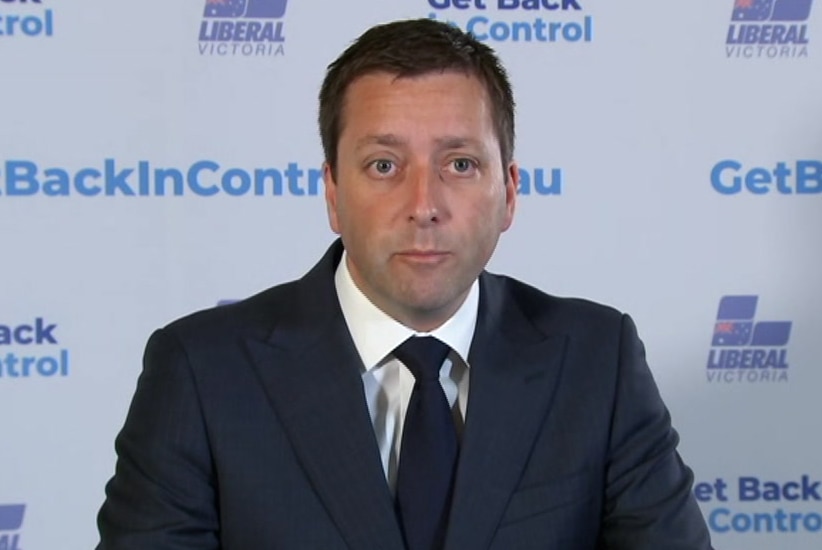 Matthew Guy speaks at a press conference in front of a Liberal Party banner.